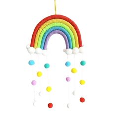 a rainbow mobile hanging from a string with pom - poms on the bottom