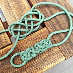 two pieces of green rope sitting on top of a wooden table