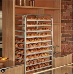 a bunch of doughnuts that are on a rack in a room with brick walls