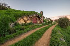 a small house on top of a hill covered in grass