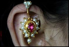 a close up of a person's ear with an earring made out of pearls