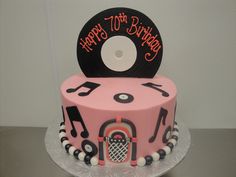 a birthday cake with a record and musical notes on it, sitting on a table