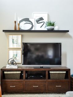 a flat screen tv sitting on top of a wooden entertainment center in a living room