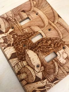 an intricately carved wooden switchplate cover with fish and sea creatures on it's sides