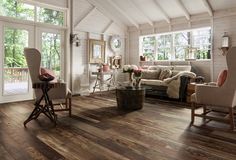 a living room filled with furniture and lots of windows on top of a wooden floor