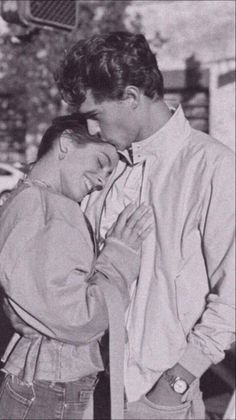 black and white photograph of a couple embracing each other in front of a street light