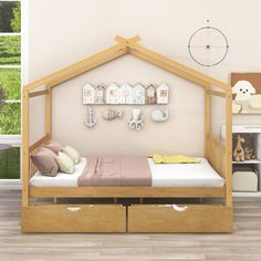 a child's bed with two drawers underneath it and a clock on the wall