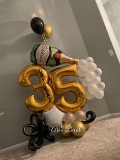 a large number 65 balloon sitting on top of a table with balloons in the shape of numbers