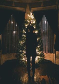 a person standing in front of a christmas tree