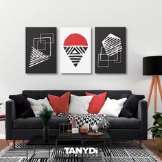 a living room with two black and white paintings on the wall, one red and one white