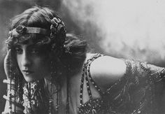 an old black and white photo of a woman with chains on her head, wearing jewelry