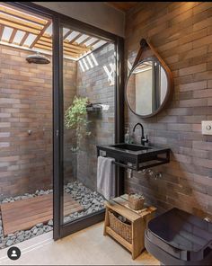 a bathroom with a sink, mirror and shower stall in the corner next to a wooden bench