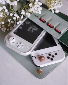 a cell phone sitting on top of a table next to a vase with white flowers