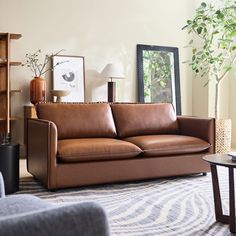 a living room filled with furniture and a large mirror on the wall next to it