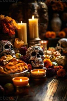 two skulls sitting next to each other with candles in front of them on a table