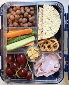 a plastic container filled with different types of food and meats on top of it