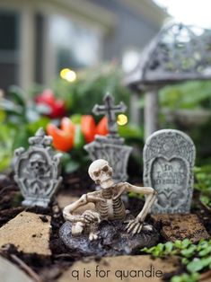 skeleton figurines sitting on the ground in front of flowers