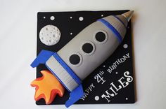 a birthday cake made to look like a rocket ship on a black and white background