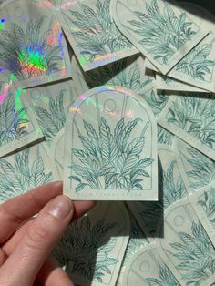 a person holding a cd in front of a pile of cds with designs on them