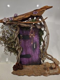 a purple door is surrounded by branches, flowers and other things that are attached to it