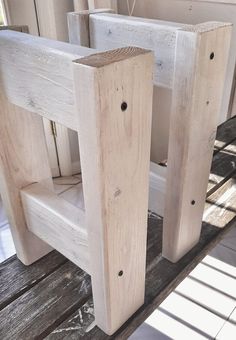 two unfinished wooden chairs sitting on top of a wood floor next to a door and window