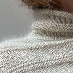 a close up of a person wearing a white sweater