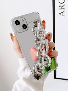 a woman holding up a cell phone case with a chain attached to the back of it