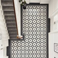 a black and white tiled floor next to stairs