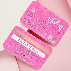 two pink glitter business cards sitting on top of each other