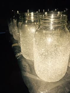 there are many jars with lights in them on top of the plastic wrapper that is wrapped around each jar