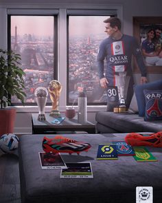 a man standing in front of a window next to a couch with soccer memorabilia on it