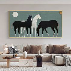 a living room with two horses on the wall and a coffee table in front of it