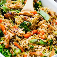 a white bowl filled with rice, broccoli and carrots