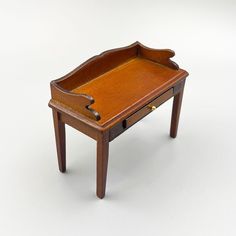 a small wooden table with an open drawer on the top and one drawer at the bottom