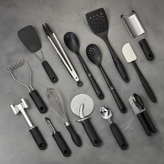 an assortment of kitchen utensils and spatulas on a gray table top