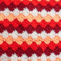 an orange and white crocheted blanket is shown