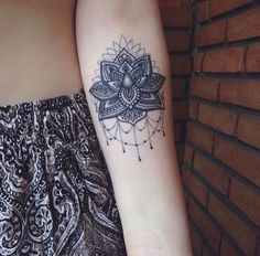 a woman's arm with a tattoo on it and a flower in the middle