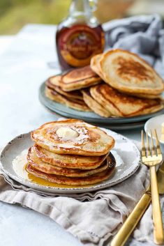 pancakes on plates with butter and syrup in the background