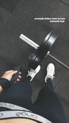 a person with their feet on the ground holding a barbell