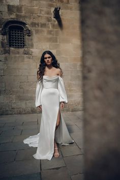 a woman in a white dress is standing outside