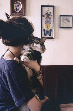 a woman holding a cat in her arms