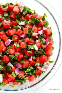 watermelon salad with cilantro and onions in a glass bowl on a white background