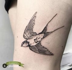 a small bird tattoo on the thigh