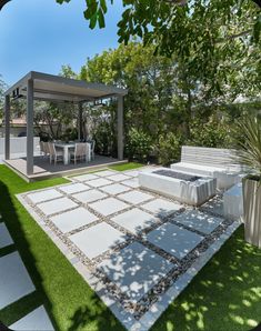 an outdoor patio area with grass and white furniture