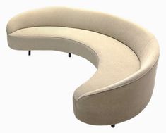 a curved couch sitting on top of a white floor