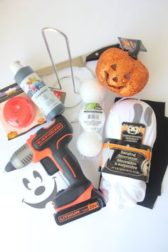 the contents of a halloween costume laid out on top of a white table with a pumpkin