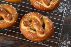 three pretzels on a cooling rack with sesame seeds