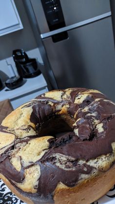 a chocolate swirl doughnut sitting on top of a white and black table cloth next to an oven