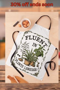 an apron with the words fluent in plants language on it next to other items