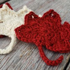 a crocheted red and white hat sitting on top of a wooden table